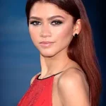 Zendaya in a red sequin dress at a red carpet event.