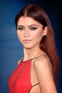 Zendaya in a red sequin dress at a red carpet event.