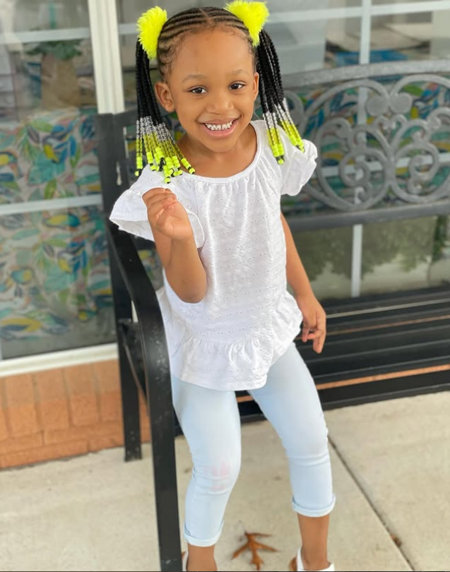 Berkeley Hermès Roberts smiling in white outfit with yellow braided hair