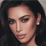 Kim Kardashian close-up with glossy nude lips and diamond stud earring